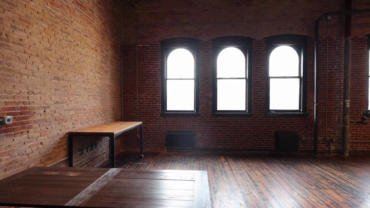 Three arched windows above a low table and timber floor