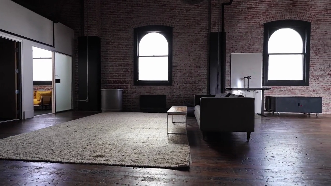 A sofa and a pale rug beneath two arched windows